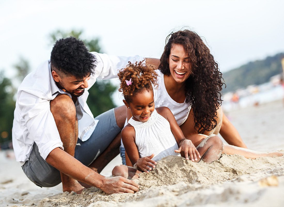 Personal Insurance - Young Family Sitting and Relaxing at the Beach on Beautiful Summer Day and Playing in the Sand